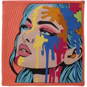 Art quilt portrait of a woman with vibrant splashes of different colored paint cascading down her cheek.