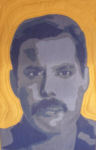 An Art Quilt of a male Singer in shades of blue against a yellow background